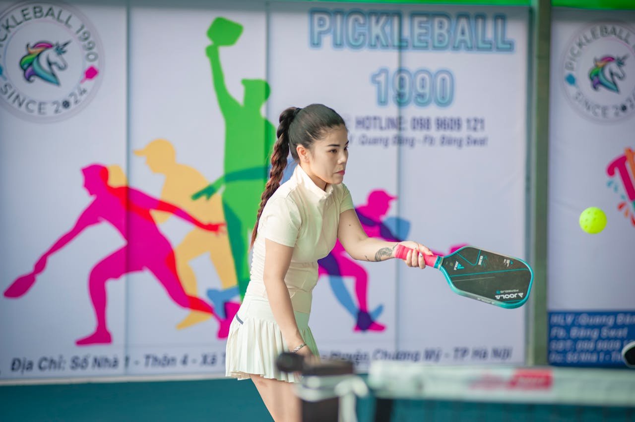 about-05 Woman actively engaged in a game of pickleball indoors in Hanoi, Vietnam.