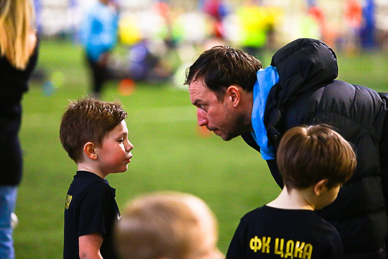 services-10 A soccer coach gives guidance to young boys during an indoor soccer training session.